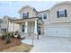 Attractive two-story home featuring a covered front porch with stone accents and a two-car garage at 2654 Mourning Dove Drive (Lot 39), Grayson, GA 30017