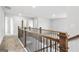 Upstairs hallway with carpet, wood and iron railing, and multiple doors at 744 Great Oak Pl, Villa Rica, GA 30180