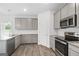 Modern kitchen featuring stainless steel appliances, gray cabinets, granite countertops, and hardwood floors at 744 Great Oak Pl, Villa Rica, GA 30180