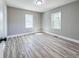 Well-lit bedroom featuring luxury vinyl flooring, neutral paint, two windows, and white trim at 1238 Westboro Sw Dr, Atlanta, GA 30310