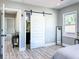 Bedroom with modern style, featuring the barn door entry to the bathroom and ample natural light at 1238 Westboro Sw Dr, Atlanta, GA 30310