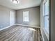 Clean bedroom with wood-look floors, neutral walls, bright windows, and new light fixture at 1238 Westboro Sw Dr, Atlanta, GA 30310