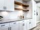 Stylish kitchen with floating shelves, granite countertops, and white cabinets at 1238 Westboro Sw Dr, Atlanta, GA 30310