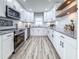 Bright kitchen featuring white cabinets, granite countertops, stainless steel appliances and wood-look flooring at 1238 Westboro Sw Dr, Atlanta, GA 30310