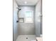 Modern shower with marble-look tiles, rain shower head, and a stylish inset shelf for toiletries at 1238 Westboro Sw Dr, Atlanta, GA 30310