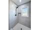 Bright shower featuring white marble tile, a modern shower head, and a convenient inset shelf at 1238 Westboro Sw Dr, Atlanta, GA 30310