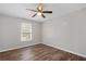 This bedroom features hardwood floors, a ceiling fan, and a window letting in natural light at 3645 Fay Dr, Rex, GA 30273