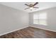 This bedroom features hardwood floors, a ceiling fan, and a window letting in natural light at 3645 Fay Dr, Rex, GA 30273