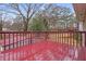 The red-stained wood deck overlooks the backyard with a few trees in the background at 3645 Fay Dr, Rex, GA 30273