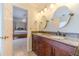 Bright bathroom features a double sink vanity with granite countertop and framed mirrors; bedroom visible in background at 45 Somerset Ct, Covington, GA 30016