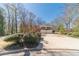 Two-story yellow home with blue shutters, surrounded by greenery, featuring a spacious driveway at 45 Somerset Ct, Covington, GA 30016