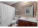 Bathroom with shower, toilet, small wooden sink, and storage shelf at 1312 Brandl Sw Dr, Marietta, GA 30008