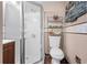 Standard bathroom featuring a stall shower with glass doors, a toilet, and a metal shelving unit at 1312 Brandl Sw Dr, Marietta, GA 30008
