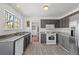 Well-lit kitchen with stainless steel appliances, gray cabinetry, and a view to the yard through a window at 1312 Brandl Sw Dr, Marietta, GA 30008