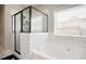 Modern bathroom featuring a glass-enclosed shower, soaking tub, and tiled walls at 844 Pool Rd, Hiram, GA 30141