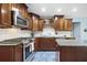 A kitchen with wood cabinets, granite countertops, subway tile backsplash, and stainless steel appliances at 985 Lake Haven Ct, Roswell, GA 30076