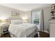 Cozy bedroom features a neutral palette, window with natural light, and stylish bedside table with lamp at 2901 Lenox Rd # 1002, Atlanta, GA 30324