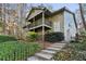 Two-story home featuring double balconies, green siding, steps, and lush ground cover at 2901 Lenox Rd # 1002, Atlanta, GA 30324