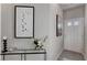 Tastefully decorated hallway with console table, art, floral arrangement, and a white front door at 5185 Longview Run, Decatur, GA 30035