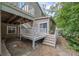 View of the back of house with a deck and access to the backyard with stone pathway and wooded landscaping at 3278 Winter Wood Ct, Marietta, GA 30062