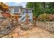 Outdoor stone patio featuring a circular fire pit and retaining walls filled with potted plants at 3278 Winter Wood Ct, Marietta, GA 30062