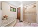 Bathroom featuring a marble jacuzzi tub, glass enclosed shower, and a window at 3278 Winter Wood Ct, Marietta, GA 30062