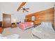 Bedroom with vaulted ceiling, wood wall, and two beds with a ceiling fan at 3278 Winter Wood Ct, Marietta, GA 30062