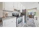 Bright kitchen area showcasing stainless steel appliances and white cabinetry, leading to a dining area at 3278 Winter Wood Ct, Marietta, GA 30062