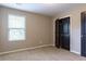 Neutral bedroom featuring window views and closet with modern, black doors at 257 Stone Park Dr, Woodstock, GA 30188