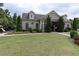 A well-maintained clubhouse with a manicured lawn, mature landscaping, and charming architectural details at 257 Stone Park Dr, Woodstock, GA 30188