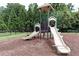 Community playground with slides and climbing structure surrounded by mature trees and a black fence at 257 Stone Park Dr, Woodstock, GA 30188