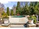 Backyard pool area with lush green landscaping, mature trees, and decorative planters at 2770 Wooded Hills Walk, Marietta, GA 30062