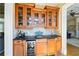 Elegant bar area with custom wood cabinets, black countertop, wine fridge, and a view to another living space at 2770 Wooded Hills Walk, Marietta, GA 30062