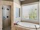 Bright bathroom featuring a soaking tub, shower, and tile surround at 2770 Wooded Hills Walk, Marietta, GA 30062