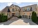 Stately brick home featuring a three car garage and a meticulously landscaped front yard at 2770 Wooded Hills Walk, Marietta, GA 30062