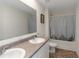 Bathroom featuring double sinks and a shower/tub combo with gray and white shower curtain at 294 Broder Farms Dr, Stockbridge, GA 30281