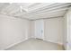 Unfinished basement featuring a white ceiling, painted walls, and a doorway at 2447 Old Peachtree Rd, Duluth, GA 30097