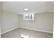 Finished basement area with light-colored flooring, neutral walls, and a window for natural light at 2447 Old Peachtree Rd, Duluth, GA 30097