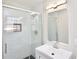 Modern bathroom featuring a glass shower, vanity with stylish fixtures, and a rectangular mirror at 2447 Old Peachtree Rd, Duluth, GA 30097