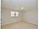 Bright bedroom with a neutral color palette, plush carpet, and a window for natural light at 2447 Old Peachtree Rd, Duluth, GA 30097