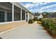 Home exterior showcases an enclosed sunroom, a concrete patio and mature landscaping at 303 Dexter Dr, Woodstock, GA 30188