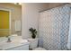 Well-lit bathroom features a vanity with sink, toilet, and a shower-tub with stylish curtain at 303 Dexter Dr, Woodstock, GA 30188