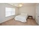 Neutral bedroom offers a cozy retreat with a window, carpet, and adjacent closet and door at 303 Dexter Dr, Woodstock, GA 30188