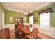 This dining room offers hardwood floors, decorative molding, and green walls at 303 Dexter Dr, Woodstock, GA 30188