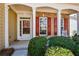 Inviting covered front porch with brick accents, white columns, and trimmed shrubbery at 303 Dexter Dr, Woodstock, GA 30188