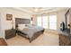 Spacious main bedroom features a large window, ceiling fan, and tray ceiling at 303 Dexter Dr, Woodstock, GA 30188