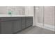 Modern bathroom features a double vanity with gray cabinets and a glass-enclosed shower at 320 Mahone Dr, Lilburn, GA 30047