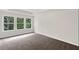 Bedroom with carpet, three large windows, and natural lighting at 320 Mahone Dr, Lilburn, GA 30047