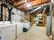Laundry area in unfinished basement features washer, dryer, and utility sink at 46 W Belle Isle Rd, Atlanta, GA 30342