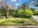 View of the home's front yard showing healthy green grass, trimmed bushes, and a stone retaining wall at 46 W Belle Isle Rd, Atlanta, GA 30342
